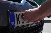 Koszovói szerb férfi ragasztja le rendszámtábláját