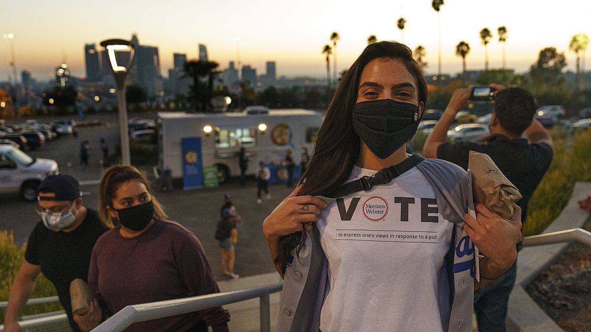 Archivo: una joven lleva una camiseta con el tema de Merriam-Webster en la que se lee: "Votar: expresar la propia opinión en respuesta a una petición".