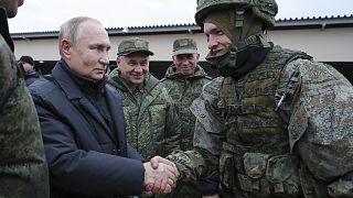 Russian President Vladimir Putin shakes hands with a soldier as he visits a military training centre of the Western Military District, 20 October 2022