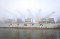 The container ship "Cosco Pride" lies in dense fog at the Tollerort container terminal at the harbor in Hamburg, Germany, Wednesday, Oct. 26, 2022.