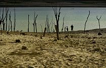 Gente caminando cerca de la frontera en el embalse de Yesa afectado por la sequía, a unos 55 kilómetros de Pamplona, norte de España, 14 de septiembre de 2022.