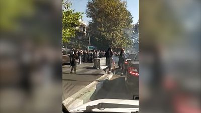 Protestierende ziehen über eine iranische Straße.