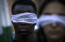 Un homme les yeux bandés durant une manifestation à Rome contre un accord entre l'Italie et la Libye