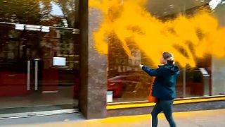 ناشط منظمة جاست ستوب أويل يرش واجهة في لندن بطلاء برتقالي.