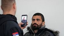 A Serbian Commissariat for Refugees and Migration worker takes photo of a migrant during registration at reception camp near the southern border with North Macedonia.