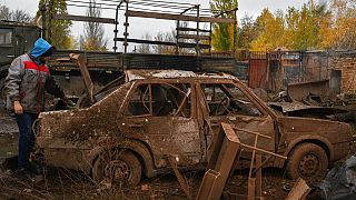 A local resident stands next to his car that was damaged after an overnight Russian attack in Kramatorsk, Ukraine, Thursday, Oct. 27, 2022.