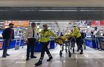 Le personnel d'urgence transporte une personne blessée dans un supermarché d'Assago, en Italie, le jeudi 27 octobre 2022.