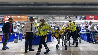 Le personnel d'urgence transporte une personne blessée dans un supermarché d'Assago, en Italie, le jeudi 27 octobre 2022.