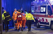 Orvosok egy sérültet mentőautóba tesznek az assagói késes támadás után 2022. október 27-én