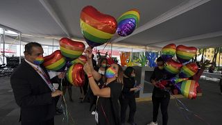 Trabajadores del registro civil mexicano decoran con globos en forma de corazón y con los colores del arco iris para una ceremonia de boda masiva entre personas del mismo sexo