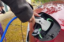Portland'da elektrikli otomobilini şarj eden bir araç kullanıcısı