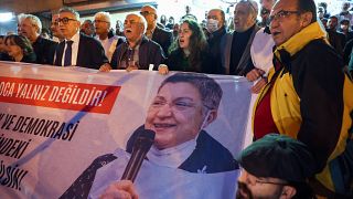 متظاهرون يحملون لافتة تحمل صورة رئيسة نقابة الأطباء التركية خلال مظاهرة ضد اعتقالها في أنقرة.