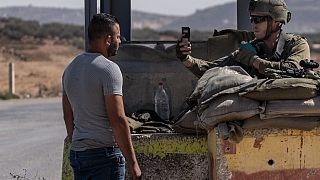 جندي من الجيش الإسرائيلي يصور فلسطينيا عند نقطة تفتيش بالقرب من مدينة نابلس بالضفة الغربية