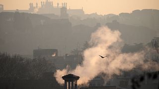 FILE - Smoke billows from chimneys of residential buildings in Rome, on Jan. 17, 2020.