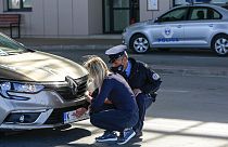 Kosova polisi, Merdare sınır kapısında bir Sırp sürücünün araç plakasına (yeni) çıkartma yapıştırmasına yardım ederken
