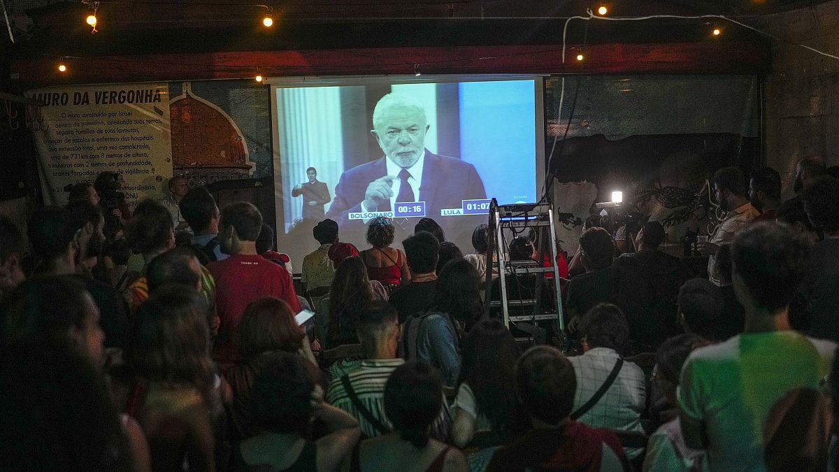 People watch at Bar Al Janiah as Brazil's former President Luiz Inacio Lula da Silva speaks during a televised presidential debate in Sao Paulo, Brazil, Friday, Oct. 28, 2022.