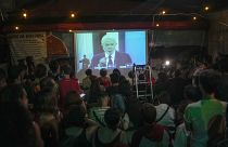 People watch at Bar Al Janiah as Brazil's former President Luiz Inacio Lula da Silva speaks during a televised presidential debate in Sao Paulo, Brazil, Friday, Oct. 28, 2022.