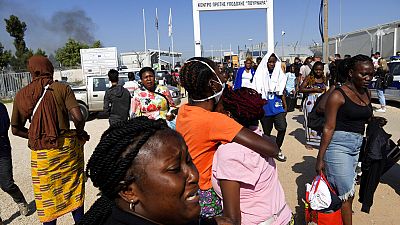 Female migrants exit the Pournara migrant reception center's main gate on the outskirts of the capital Nicosia, Cyprus, Friday, Oct. 28, 2022.