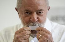 Former Brazilian President Luiz Inacio Lula da Silva, who is running for president again, kisses his ticket after voting in Sao Paulo, 30 October 2022