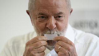 Former Brazilian President Luiz Inacio Lula da Silva, who is running for president again, kisses his ticket after voting in Sao Paulo, 30 October 2022