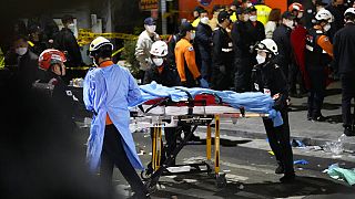 Τραυματιοφορείς μεταφέρουν σορό σε ασθενοφόρο μετά το ποδοπάτημα στη Σεούλ σε υπάιθριο πάρτι