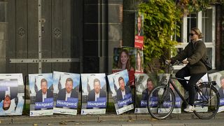 سيدة على دراجة هوائية تمر بجوار ملصقات الحملة الانتخابية في وسط مدينة كوبنهاغن، الدنمارك