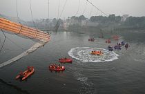 Rescuers on boats search in the Machchu river next to a cable bridge that collapsed in Morbi district, western Gujarat state, India, 31 October 2022.