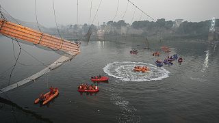 Rescuers on boats search in the Machchu river next to a cable bridge that collapsed in Morbi district, western Gujarat state, India, 31 October 2022.