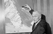 صورة أرشيفية من عام 1965 لبرادفورد واشبورن وهو يشير إلى صورة لجبل كينيدي في إقليم يوكون في كندا، بوسطن، الولايات المتحدة.