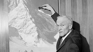 صورة أرشيفية من عام 1965 لبرادفورد واشبورن وهو يشير إلى صورة لجبل كينيدي في إقليم يوكون في كندا، بوسطن، الولايات المتحدة.