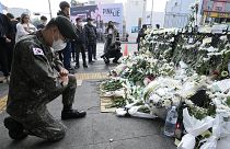 A South Korean army soldier pays tribute to victims of a deadly accident following Saturday night's Halloween festivities on a street near the scene in Seoul, 1 November 2022