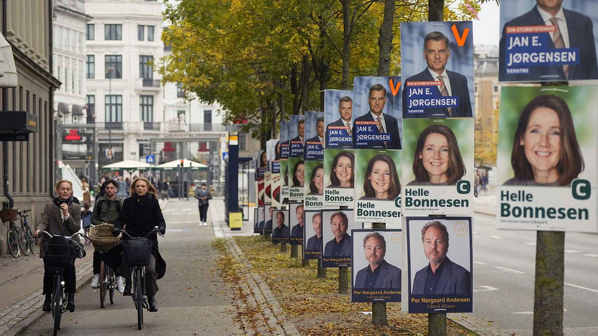 People pass by election campaign posters in Copenhagen, 31 October 2022