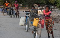 As mulheres de Machaze percorrem quilómetros de bicicleta ao calor para carregar bidões de água