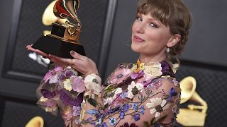 Taylor Swift poses in the press room with the award for album of the year for "Folklore" at the 63rd annual Grammy Awards in 2021.