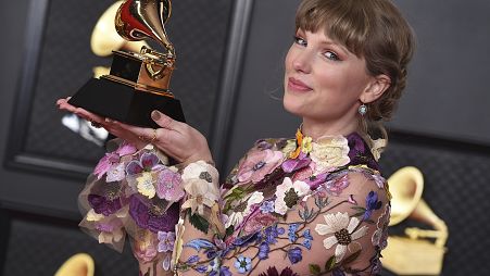 Taylor Swift poses in the press room with the award for album of the year for "Folklore" at the 63rd annual Grammy Awards in 2021.
