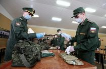 Sorozótiszt ad szájmaszkot egy frissen besorozott katonának Oroszországban 2020. májusában - Képünk illusztráció