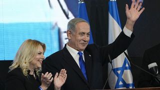 Benjamin Netanyahu, former Israeli PM and head of Likud party, with his wife Sara, waves to his supporters, at his party's headquarters in Jerusalem, Wednesday, Nov. 2, 2022.