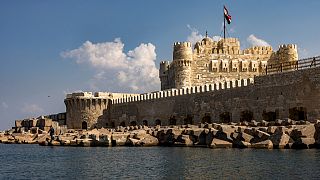 هذه الصورة التقطت في 31 أكتوبر 2022 وتُظهر كتلاً خرسانية مثبتة لكسر أمواج البحر المتوسط قبالة قلعة قايتباي بمدينة الإسكندرية التي يتهددها الغرق جراء تغير المناخ.