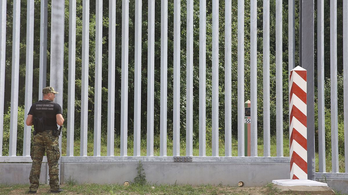 Una guardia di frontiera sorveglia la barriera costruita al confine tra Polonia e Bielorussia a Kuznice (30 giugno 2022)
