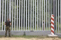 A Polish border guard patrols the area of a newly built metal wall near Kuznice.
