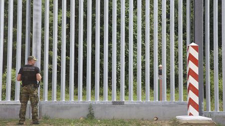 Una guardia di frontiera sorveglia la barriera costruita al confine tra Polonia e Bielorussia a Kuznice (30 giugno 2022)