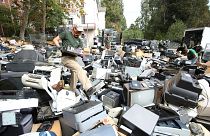 An e-waste worker wades through a sea of electronic items dropped at Mt. St. Mary's School for their annual recycling event, Grass Valley, California, Oct. 10, 2020.