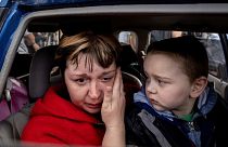 Natalia Pototska, 43, cries as her grandson Matviy looks on in a car at a center for displaced people in Zaporizhzhia, Ukraine.