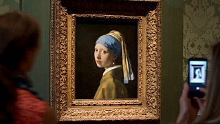 Visitors take pictures of Johannes Vermeer's 'Girl with a Pearl Earring'.