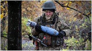 جندي أوكراني يحمل قذيفة تحمل رسالة مكتوبة إلى الجيش الروسي