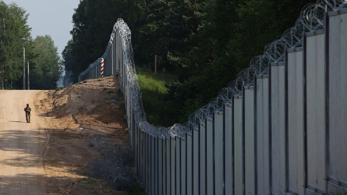 A Polish border guard patrols the area of a newly built metal wall on the border between Poland and Belarus, near Kuźnica, Poland. 
