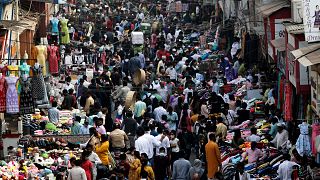 People in India wearing face masks as a precaution against the COVID-19, crowd a market, in Mumbai, India.