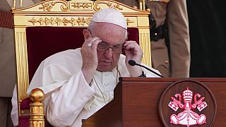 Pope Francis adjusts his glasses, as he attends the closing session of the "Bahrain Forum for Dialogue: East and west for Human Coexistence"