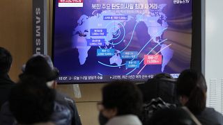 Passanten am Bahnhof von Seoul verfolgen Bericht über nordkoreanischen Raketenstart auf dem Fernsehbildschirm.