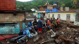 Anwohner inmitten der Trümmer nach einem Erdrutsch infolge heftiger Regenfälle